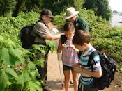 Laura Sebastianelli, in NPS uniform, and Greg Crider, FODMer, discuss insects with Mara and Colin Surovell